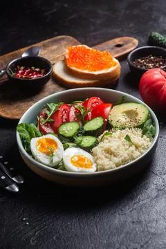 Couscous with boiled egg and vegetables in a plate on the table Stock Photos