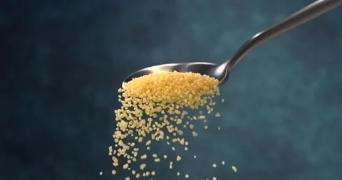 Couscous falling from a spoon in slow motion close up on blue background Stock Footage 346225928