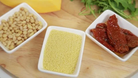 Couscous grain and dried tomatoes among other fresh ingredients Vidéo 313473840