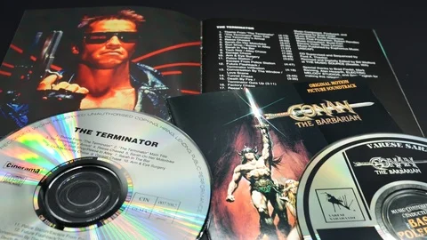 Cover and artwork of two Arnold Schwarzenegger films Stock Footage 120642858