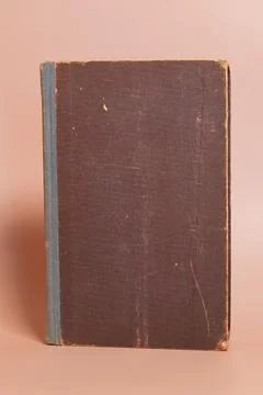 The cover of an old worn book on a colored background Stock Photos