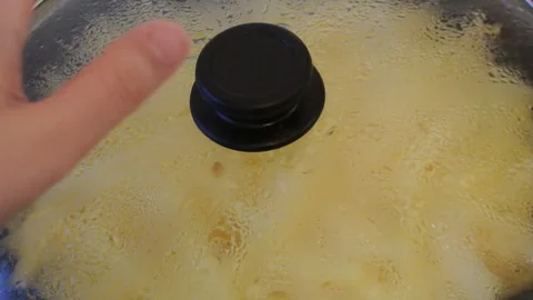 Cover pans is opened and it releases the steam. Roasting potatoes. Home kitchen. Stock Footage 82232534