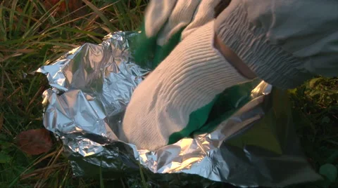 Cover portable brazier with a second lay of foil to cook a bbq hot dogs Stock-Footage 63211233