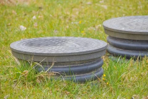 Cover sewer in the grass on the garden plot Stock Photos