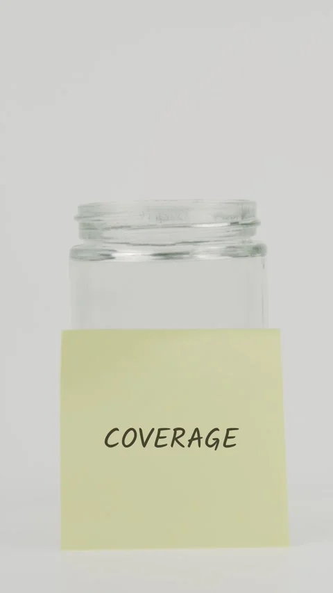 Coverage text or word on yellow sticky note attached to glass jar with hand Stock Footage 311701356