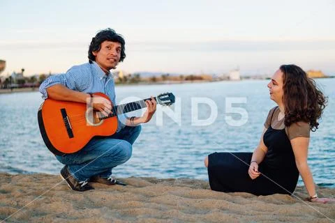 Coverband couple of musicians play acoustic guitar and sing near the beach Stock Photos