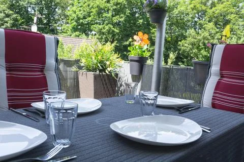 Covered balcony table with white plates Stock Photos