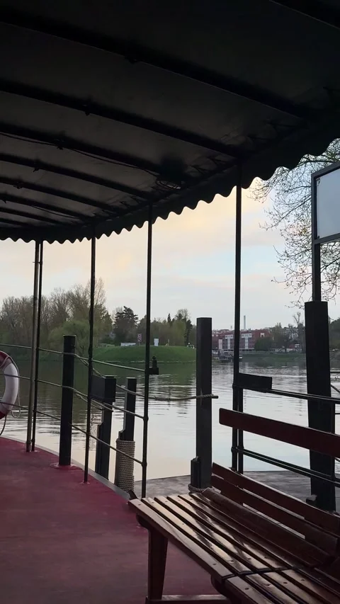 Covered boat deck, calm river water reflecting cloudy sky, tranquil natural Stock Footage 335380293