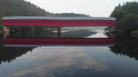 Covered bridge reflected in River in Canada Stock Footage 133849911