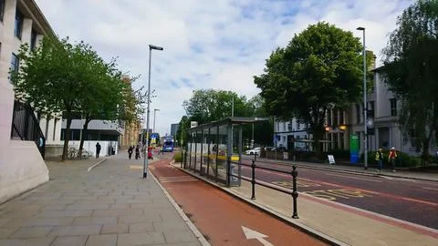 Covered bus stop on the roadside next to the bike lane with passengers waiting Stock Photos