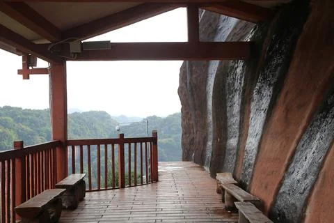 Covered cliffside viewing deck with red railings, benches, and forest valle.. Stock Photos