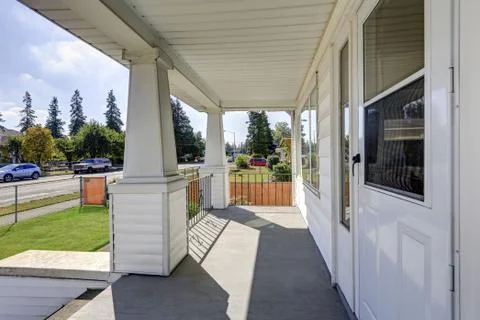 Covered column porch interior overlooking road in front of the house. Northwe Stock Photos