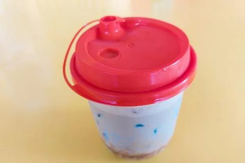 A covered cup on the yellow table. Stock Photos