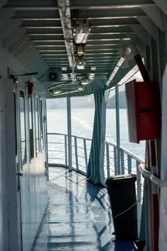 Covered Ferry Deck Walkway Overlooking Sunlit Sea Stock Photos