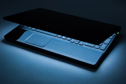 The covered laptop with the light in the dark Stock Photos