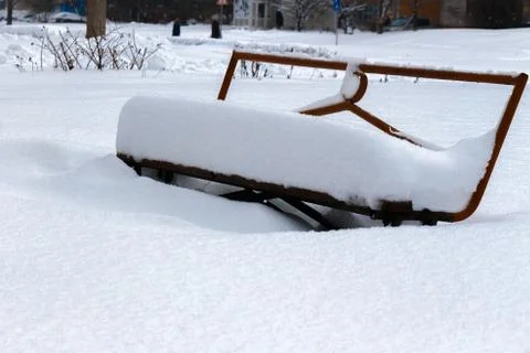 Covered with a large layer of snow bench in the city park Fotos Stock