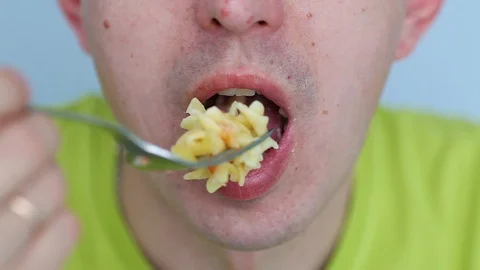 Covered by the lips of a man chews pasta. Not a healthy diet. Stock Footage 125829392