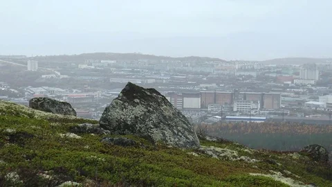 Covered with moss hillside with big rocks, the city is far away. The sleet. Stock Footage 75069287