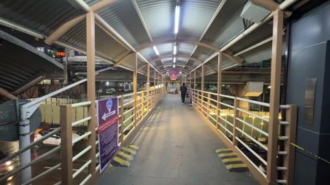 Covered pedestrian walkway with a passing train above night 4K 30fps Vídeos de archivo 337950378