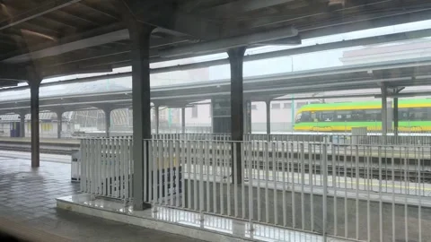 Covered train station platform and tracks on a cloudy day, featuring a mode.. Stock Footage 328591731