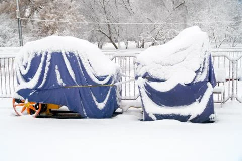 Covered train under thick snow in abandoned entertainment park 스톡 사진
