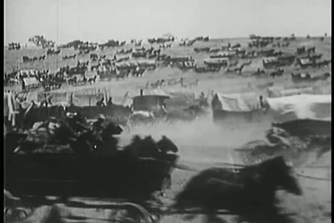 Covered wagon caravan rushing through prairie Stock Footage 11351147