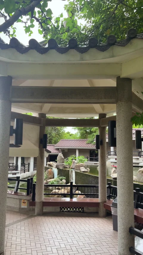 Covered Walkway With Stone Columns Beside A Garden Pond Pavilion Stock Footage 344122750
