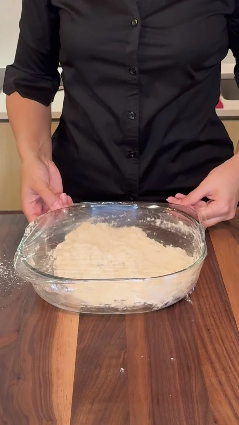 Covering Bread Dough with Plastic Wrap in Glass Bowl Before Resting Stock Footage 330677284