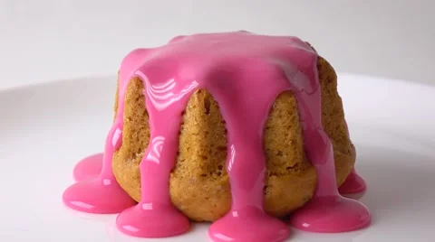Covering freshly baked muffin with pink sauce 4K video Stock Footage