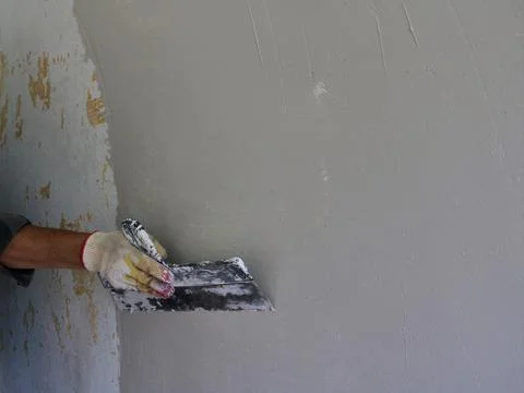Covering the wall with an even layer of putty Stock Photos