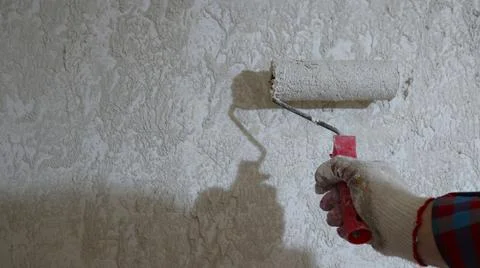 Covering a wall with mortar using a roller Stock Photos