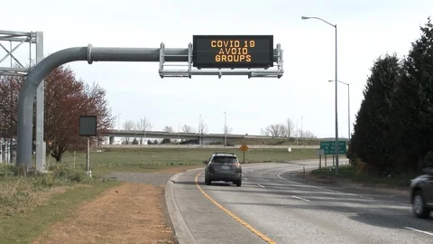 COVID 19 Avoid Groups Road Sign And Traffic Stock Footage 126931017