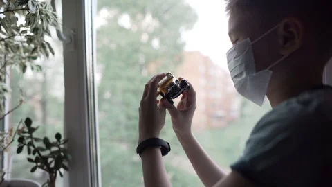 Covid -19, a boy sitting by the window in a medical mask, coronavirus pandemic Stock Footage 130137979