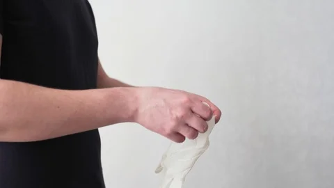 COVID-19 concept. A man wears medical white gloves. Protection from coronavirus Vidéo 126970009