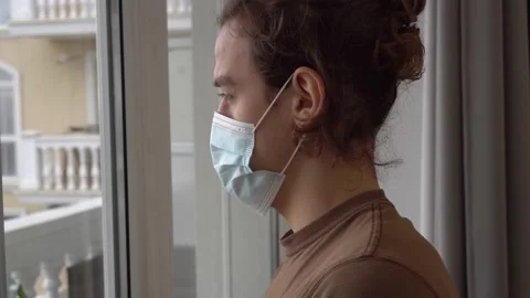 COVID-19 Coronavirus lockdown. Alone sad young man in medical mask Stock Footage 161773247