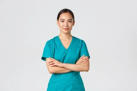 Covid-19, healthcare workers, pandemic concept. Confident smiling asian nurse in Stock Photos