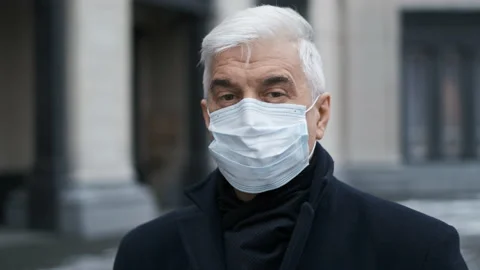 Covid 19 lockdown portrait faces. Old retired man in facemask looks at camera. Stock Footage 158341177