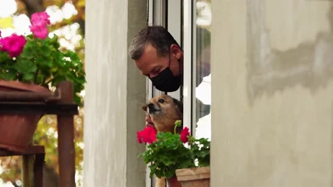 Covid-19 lockdown. Sad man with dog on home balcony. Self-isolation in Stock Footage 165814325