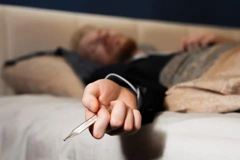 Covid-19. The man has an illness and works at home in office clothes Foto stock