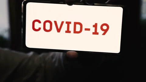 Covid-19 red writing on a screen of a mobile phone Stock Footage 130597276