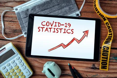 Covid-19 Statistics. Tablet computer on a wooden office desk Stock Photos