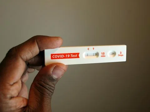 Covid-19 test kit in hand - positive Stock Photos