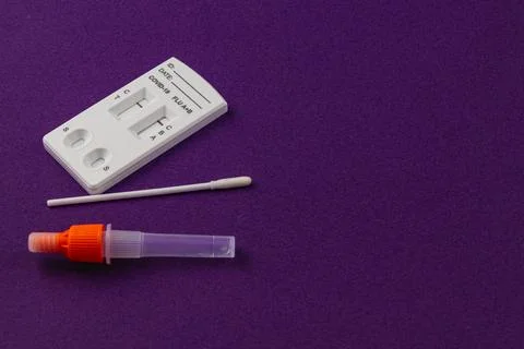 COVID-19 testing kit with sample collection swab on purple surface Stock Photos