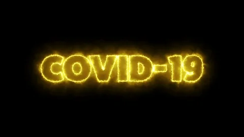 COVID-19 text word written in glowish yellow letters on a black background. Video stock 129868340
