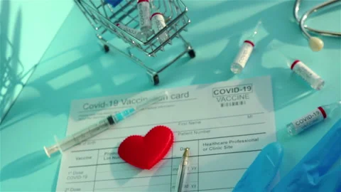 Covid 19 vaccine ampoules vaccination card syringe glove small shopping cart Stock Footage