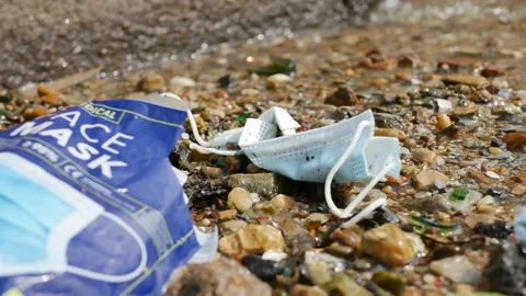 COVID face mask and package washed up as rubbish. Stock Footage 152956964