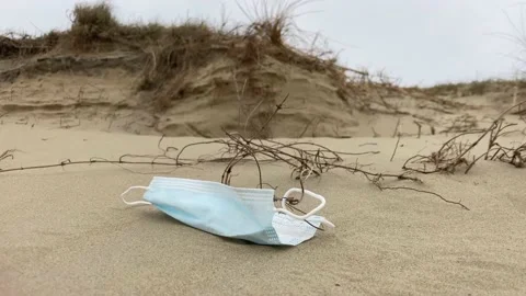 Covid face mask blowing in the wind on a beach 動画素材 151886404