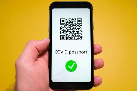 Covid pass with QR code on the screen in smartphone in mans hand on the yellow Stock Photos