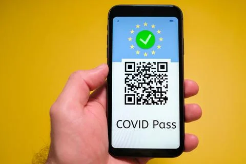 Covid pass with QR code on the screen in smartphone in mans hand on the yellow Stock Photos