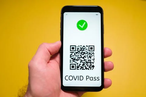 Covid pass with QR code on the screen in smartphone in mans hand on the yellow Stock Photos